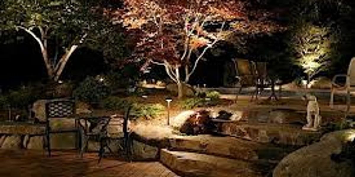 Cozy garden patio with landscape lighting at night