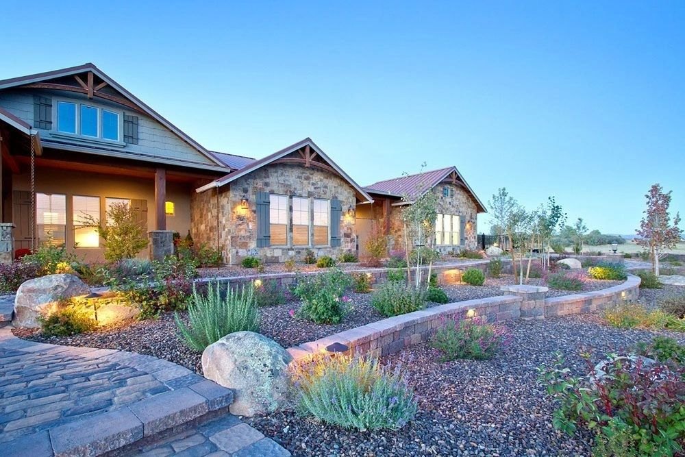 Stone home with a landscaped garden and stone pathway at twilight